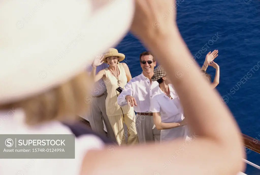 High angle view of a mid adult man and two mid adult women standing on the deck of a cruise ship