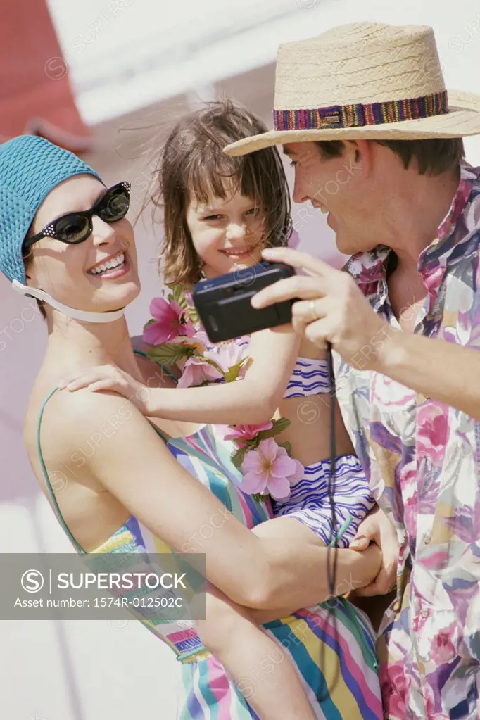 Close-up of parents with their daughter taking a photograph of themselves