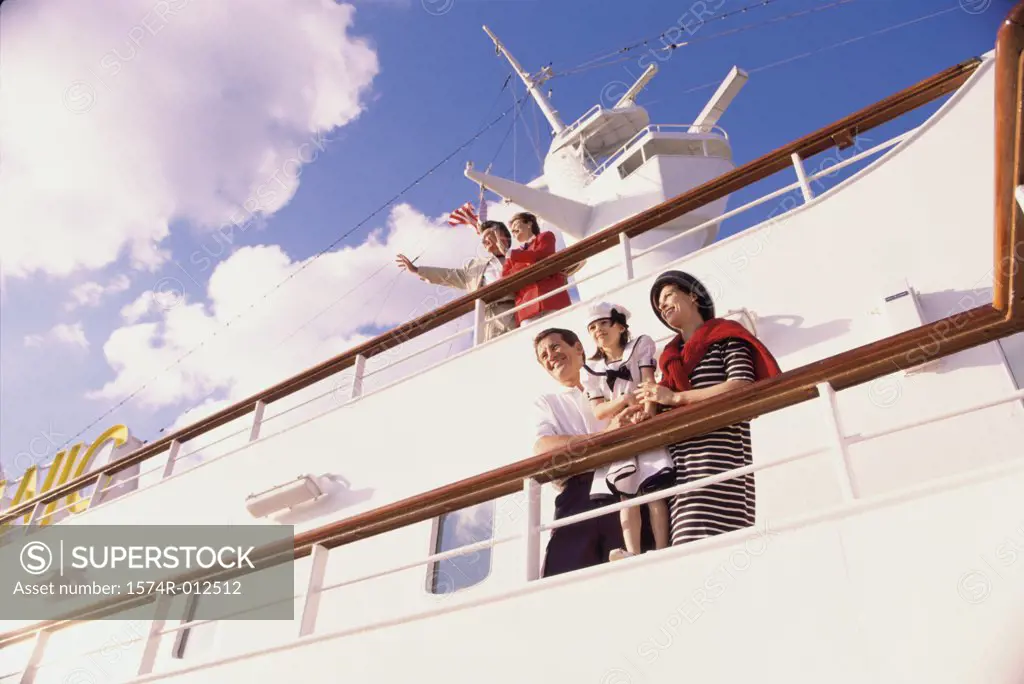 Low angle view of a mid adult couple with their daughter standing on the deck of a cruise ship
