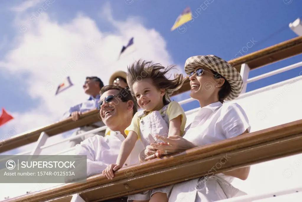 Low angle view of parents with their daughter standing on the deck of a cruise ship