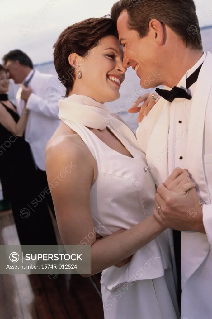Close-up of a mid adult couple dancing on the deck of a cruise ship