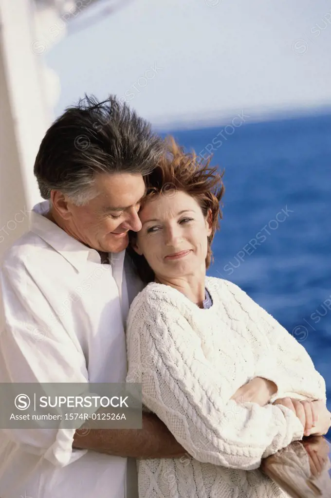Side profile of a mature man embracing a mature woman from behind
