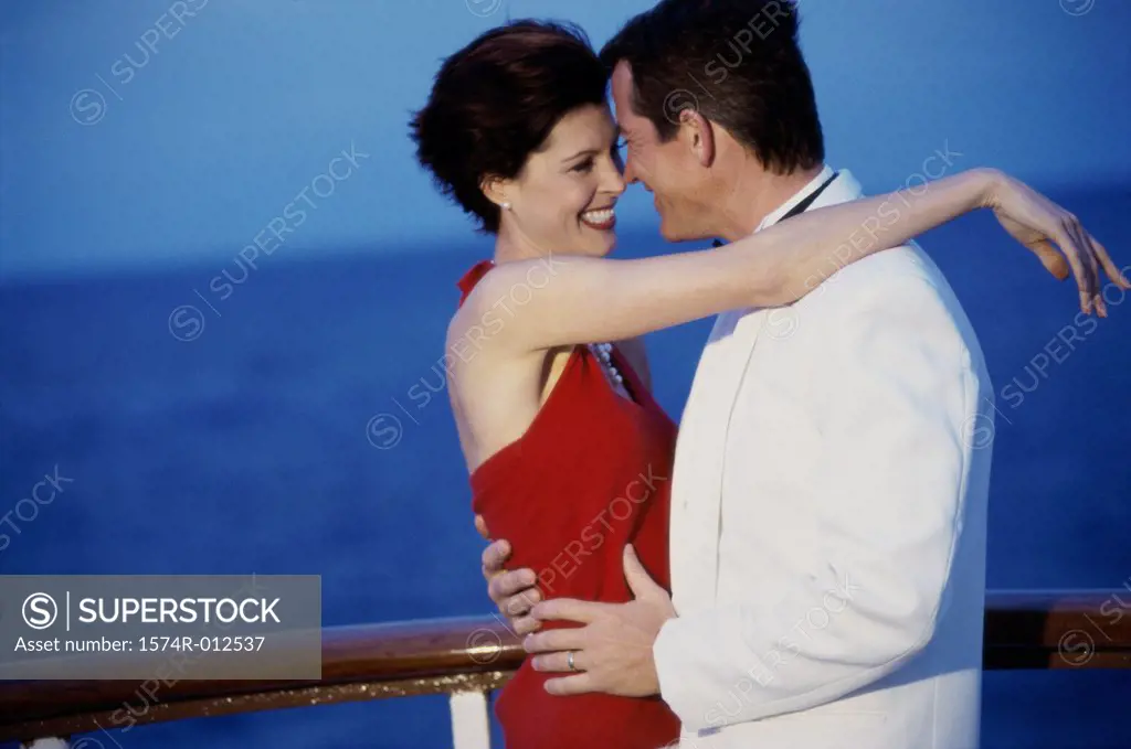 Side profile of a young couple embracing on the deck of a cruise ship