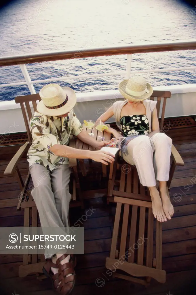 High angle view of a young couple sitting in deck chairs on a cruise ship