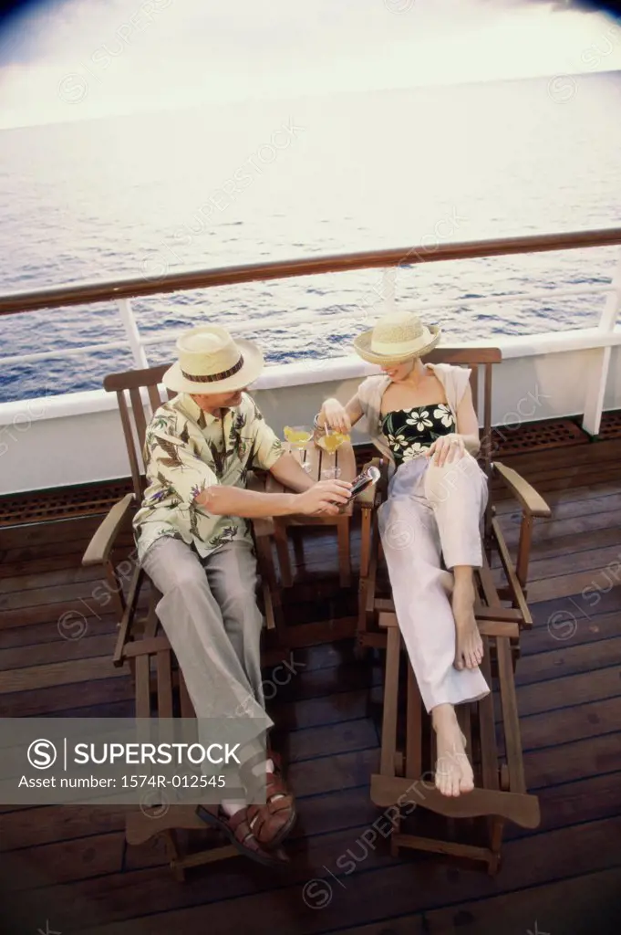 High angle view of a young couple sitting in deck chairs on a cruise ship