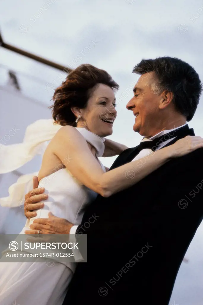 Side profile of a mature couple dancing on the deck of a cruise ship