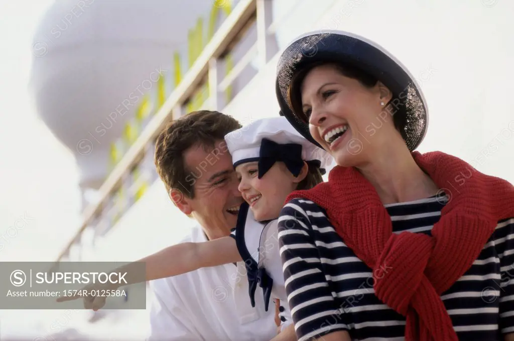 Close-up of parents standing with their daughter on a cruise ship