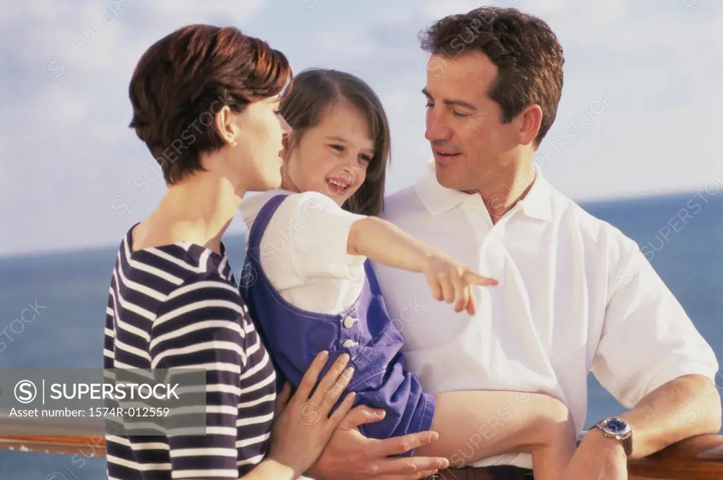 Close-up of parents standing with their daughter on a cruise ship