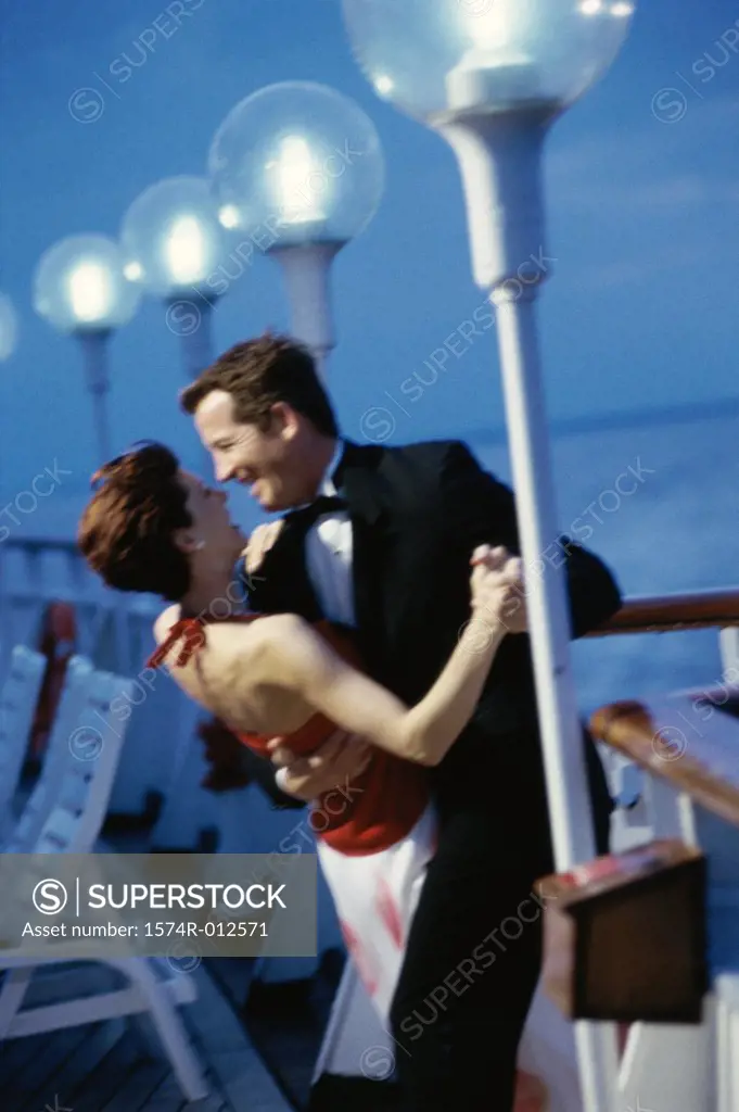 Side profile of a young couple dancing on the deck of a cruise ship