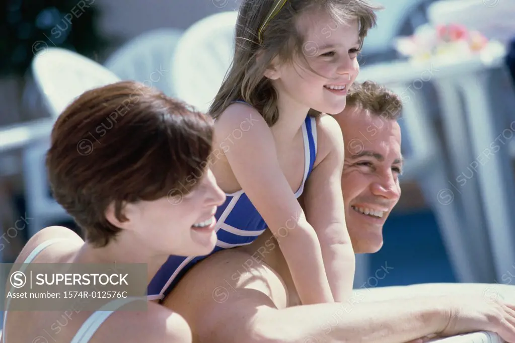 Close-up of parents with their daughter smiling on a cruise ship