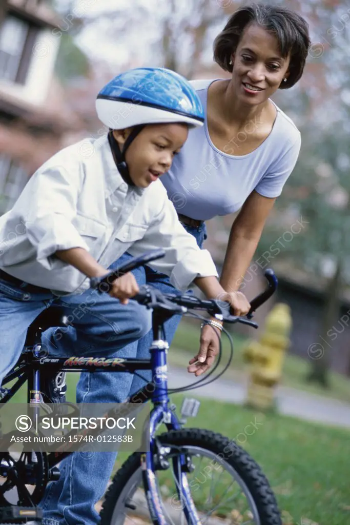 Grandmother teaching her grandson to ride a bicycle