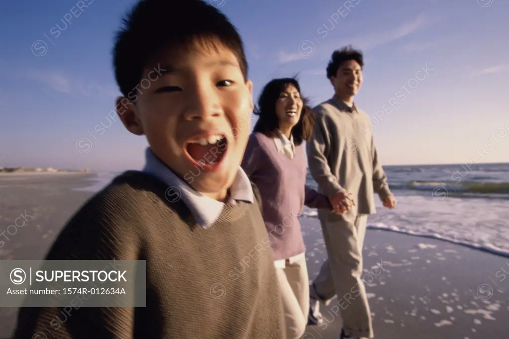 Parents and their son walking on the beach