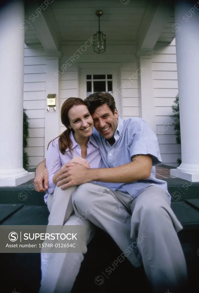 Portrait of a young couple sitting on the porch smiling