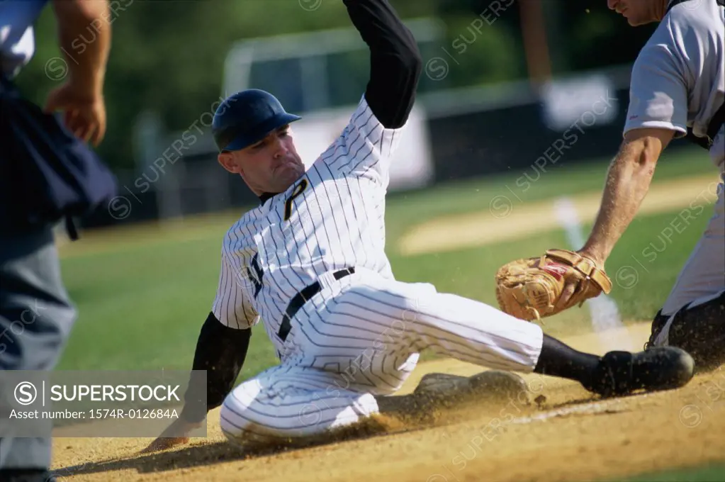 Baseball player sliding onto base