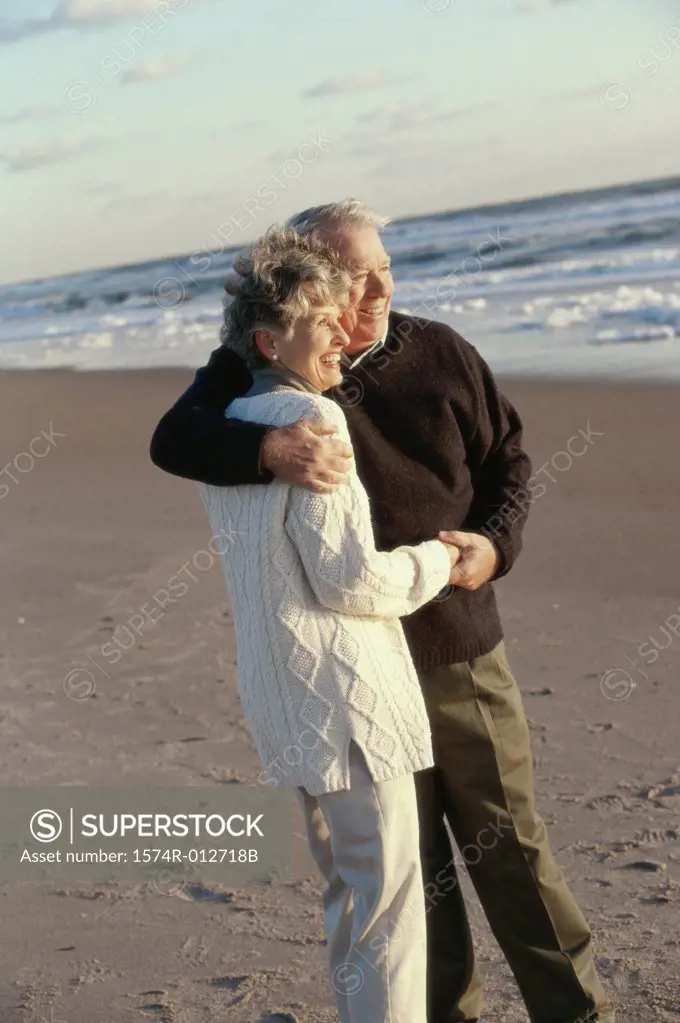 Side profile of a senior couple embracing each other on the beach