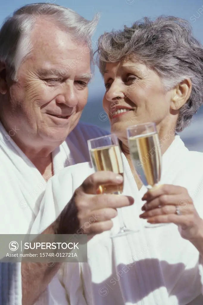 Close-up of a senior couple toasting with champagne flutes