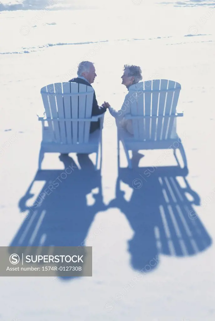 Rear view of a senior couple sitting together on the beach