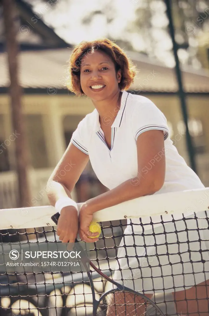 Portrait of a mature woman leaning against a tennis net
