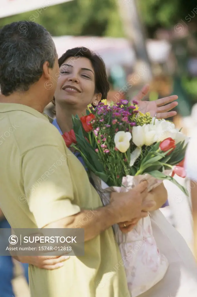 Side profile of a mature couple holding a bouquet of flowers