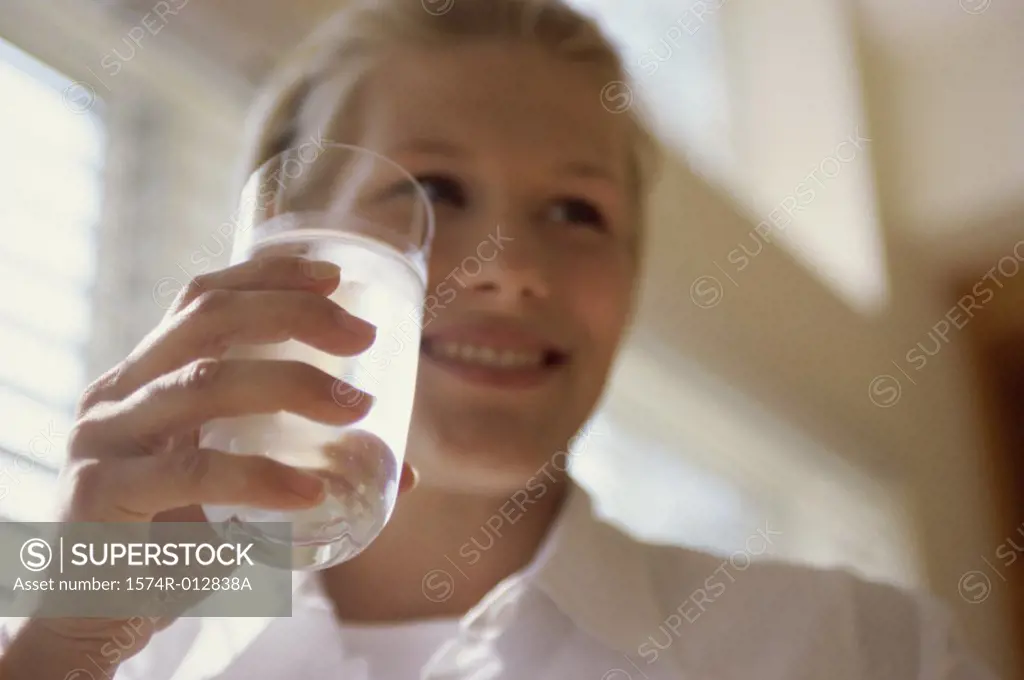 Low angle view of a young woman holding a glass of water