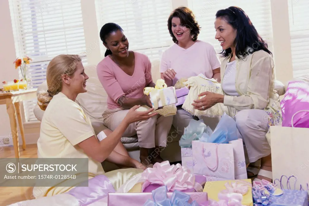 Four women opening gifts at a baby shower