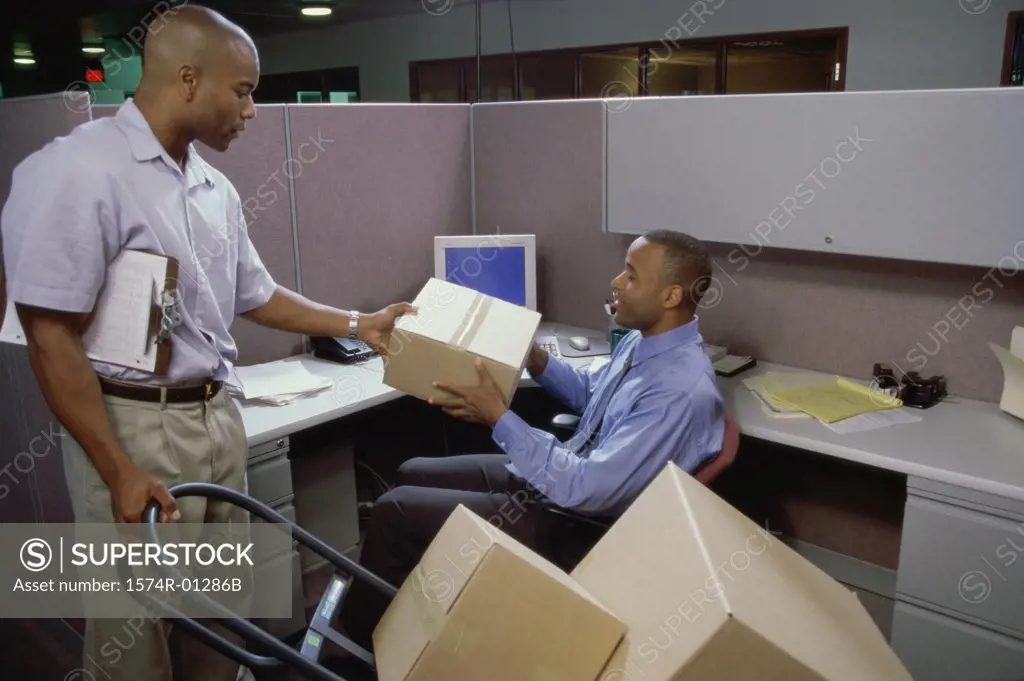 Delivery man giving a parcel to a businessman