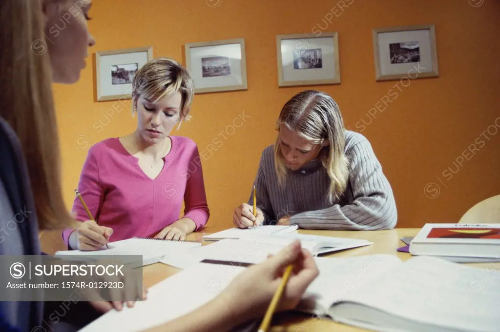 Three teenage girls studying in a room