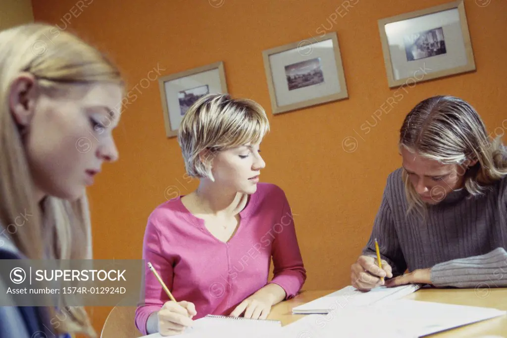 Three teenage girls studying in a room