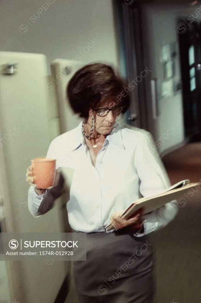 Businesswoman holding a cup of coffee and files