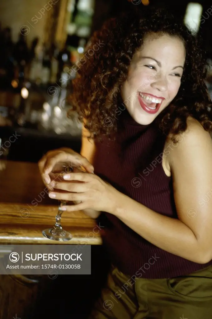 Close-up of a young woman laughing at a bar