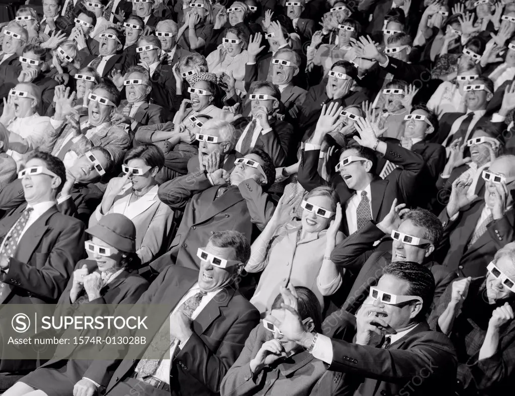 High angle view of group of spectators sitting in a movie theater wearing 3-D glasses