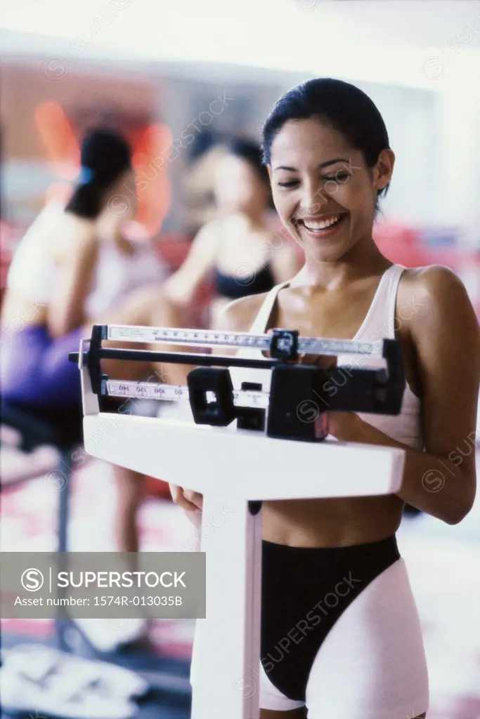 Young woman standing on a weight scale