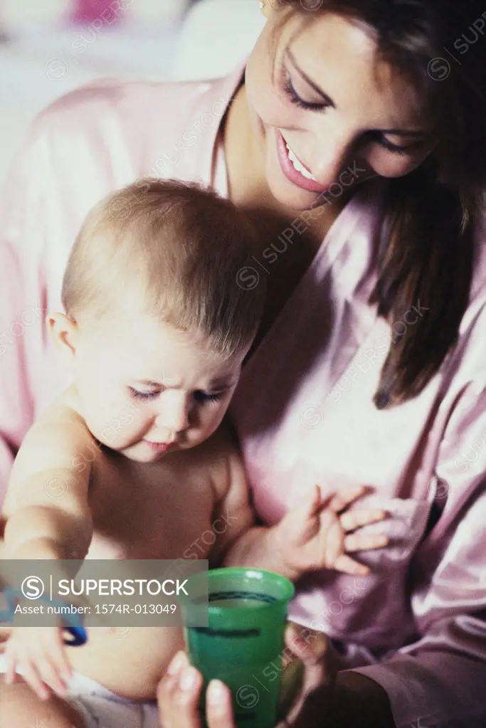 Close-up of a mother holding a cup in front of her son
