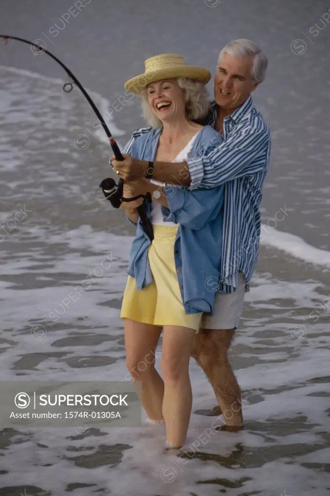 Senior couple fishing together on the beach