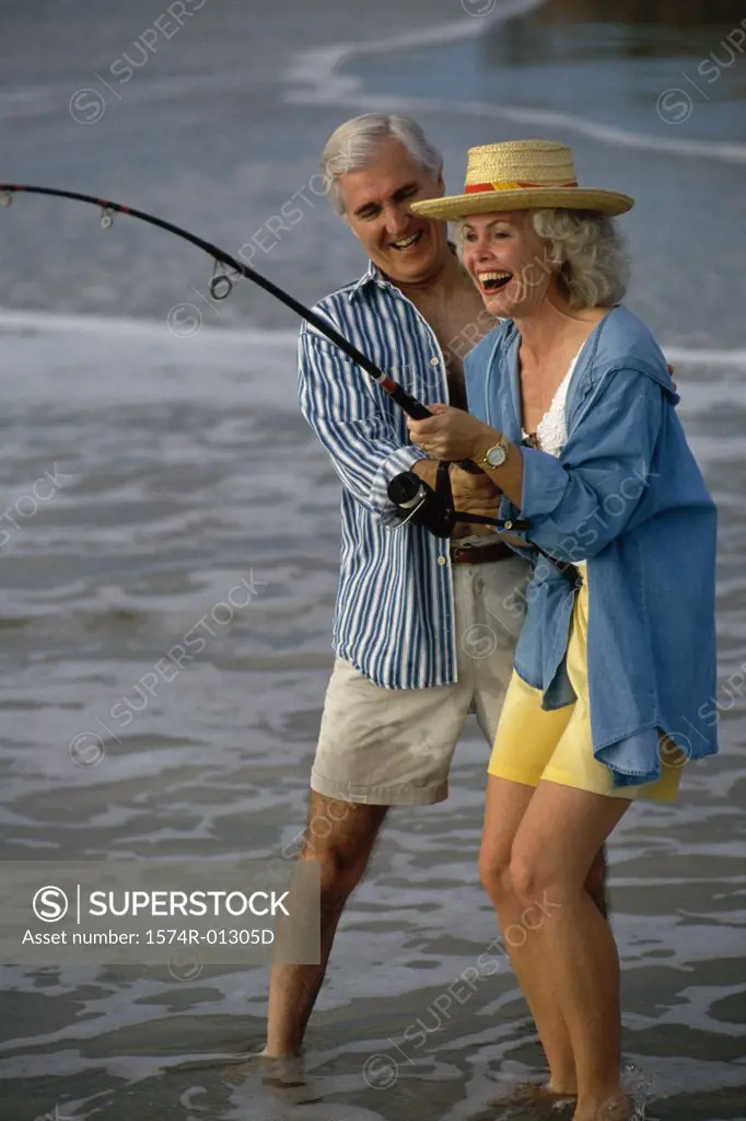 Senior couple fishing together on the beach