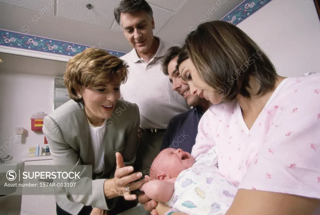 Close-up of a baby boy with his parents and grandparents in a hospital
