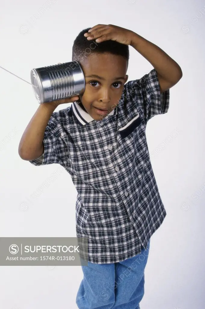 Portrait of a boy listening to a tin can phone