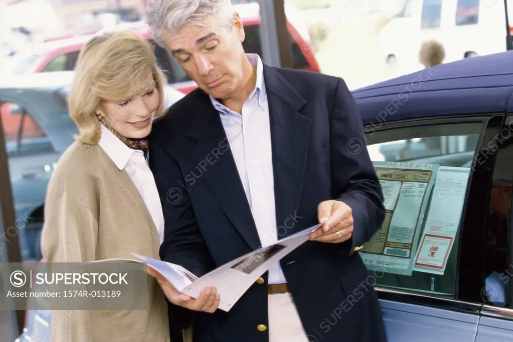 Close-up of a mature couple looking at a brochure