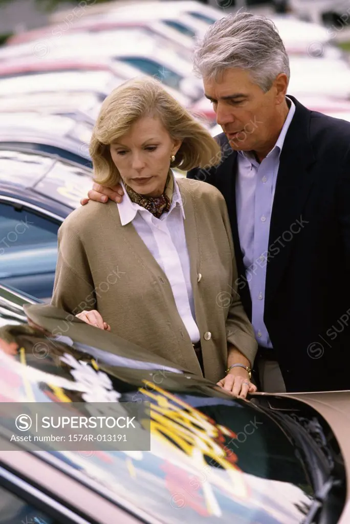 Mature couple standing near a car