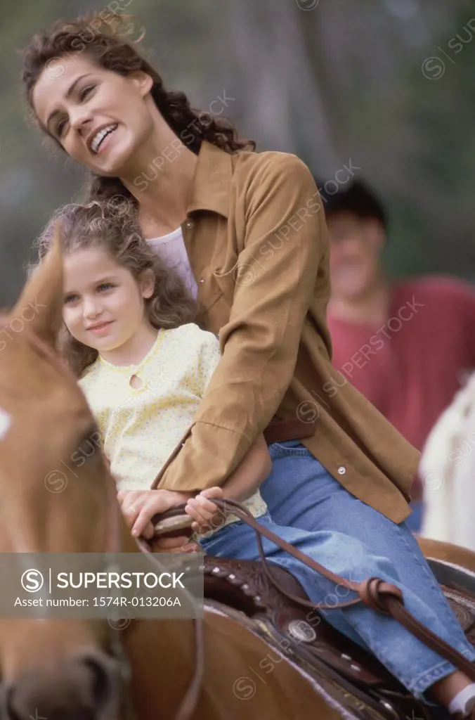 Mother and daughter riding a horse