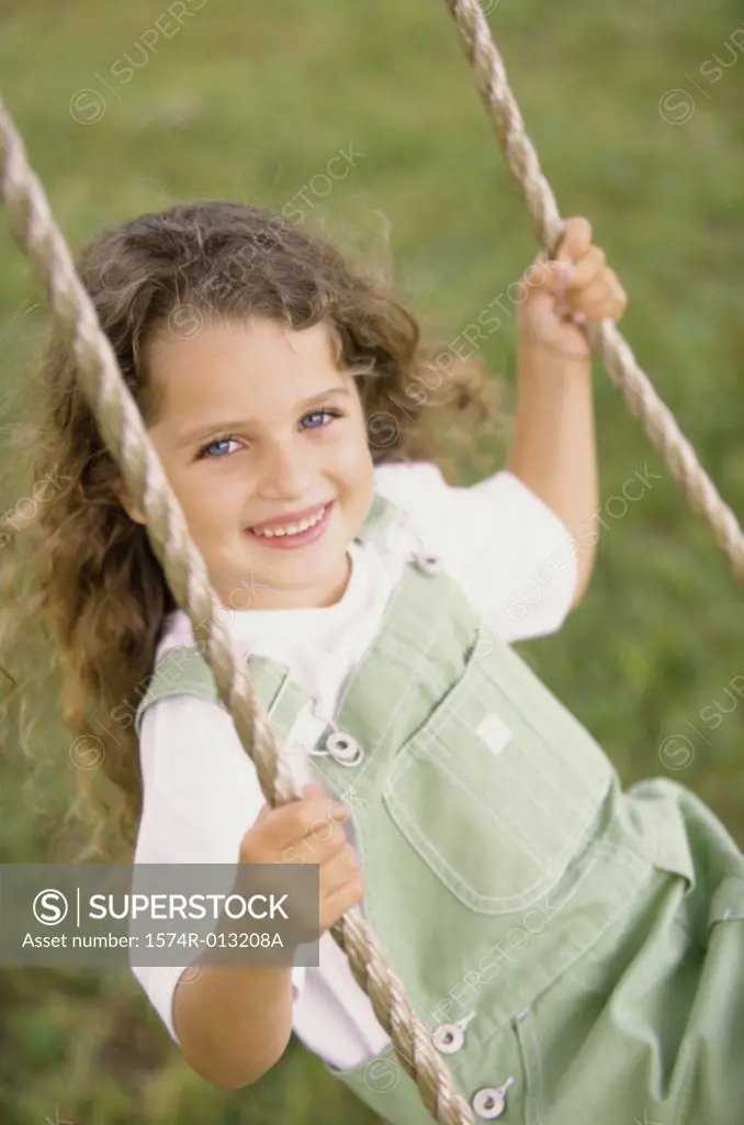 Portrait of a girl swinging on a swing