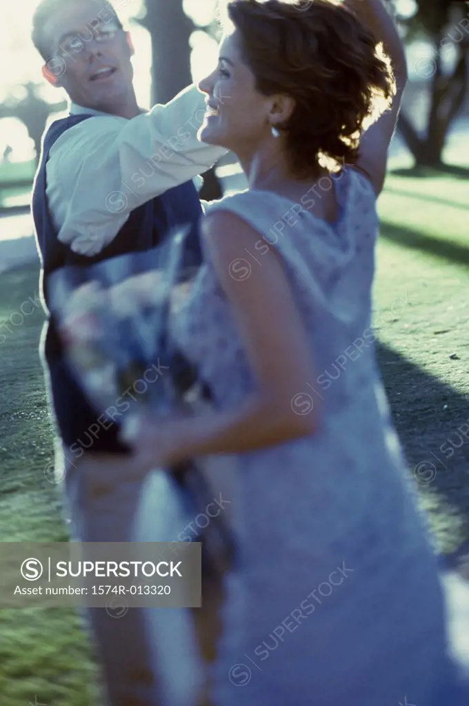 Side profile of a mature couple dancing on a lawn
