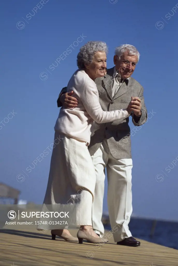 Senior couple dancing on a pier