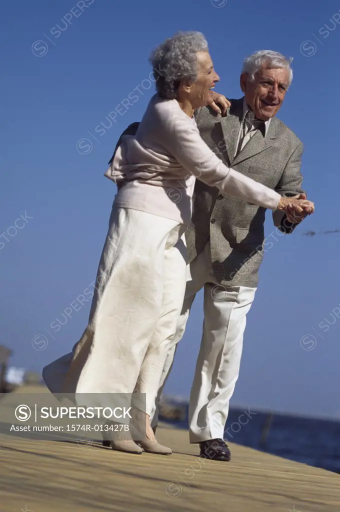 Senior couple dancing on a pier