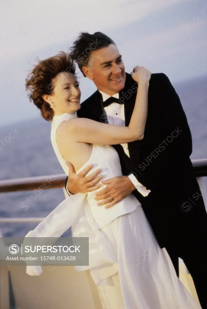 Mid adult couple holding each other on a cruise ship