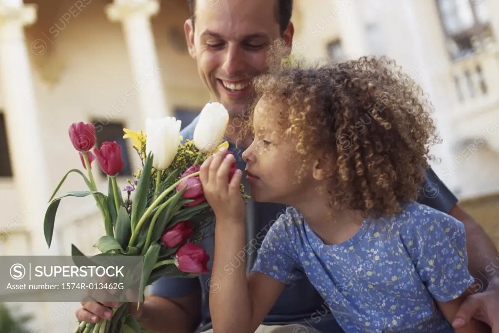 Father holding a bouquet of flowers with his daughter