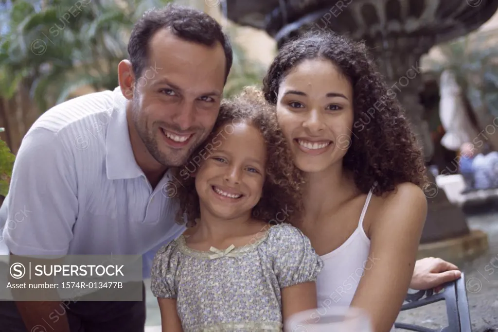 Portrait of parents smiling with their daughter