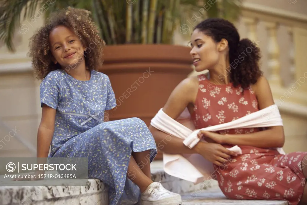 Mother and daughter sitting on steps