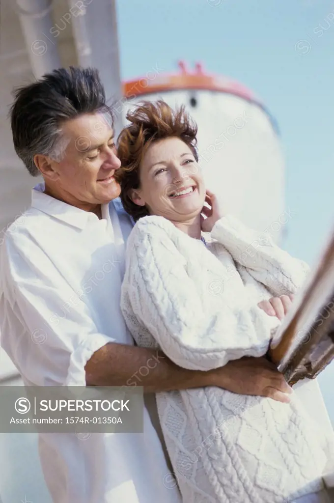 Couple standing against a railing on a ship