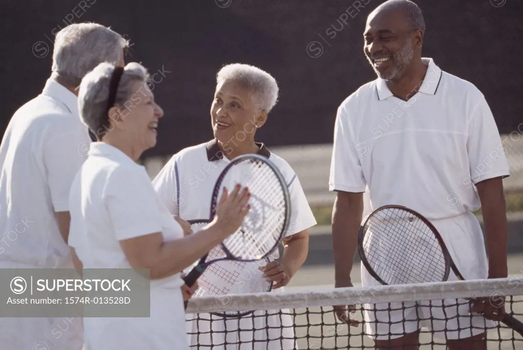 Two senior couples on a tennis court